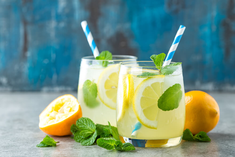 Холодный освежающий лимонад с листьями мяты в двух стаканах.