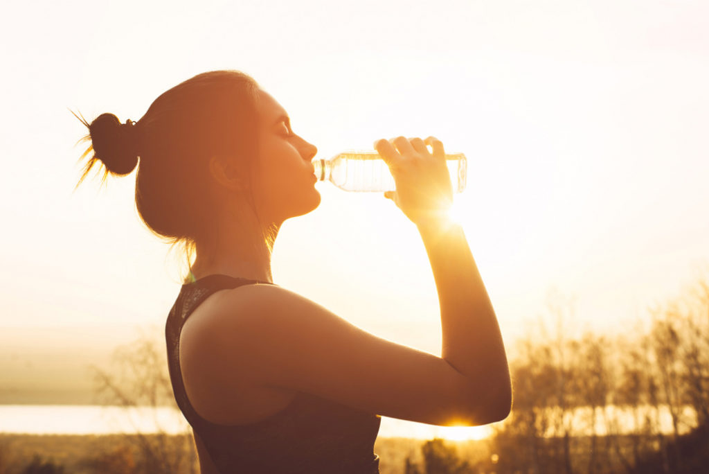 Woman drinking water between running.