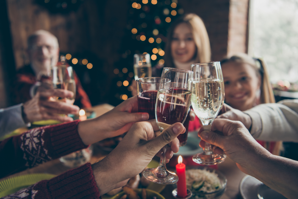 Brindisi festivo con spumante e vino bianco e rosso - tintinnio di calici.
