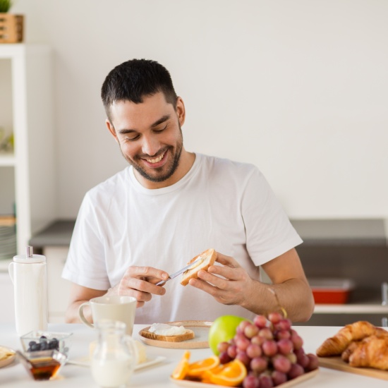 The man laughs while preparing a healthy breakfast.