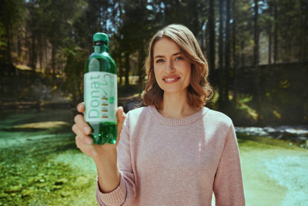 Eine Frau hält eine Flasche Donat Mg in den Händen.