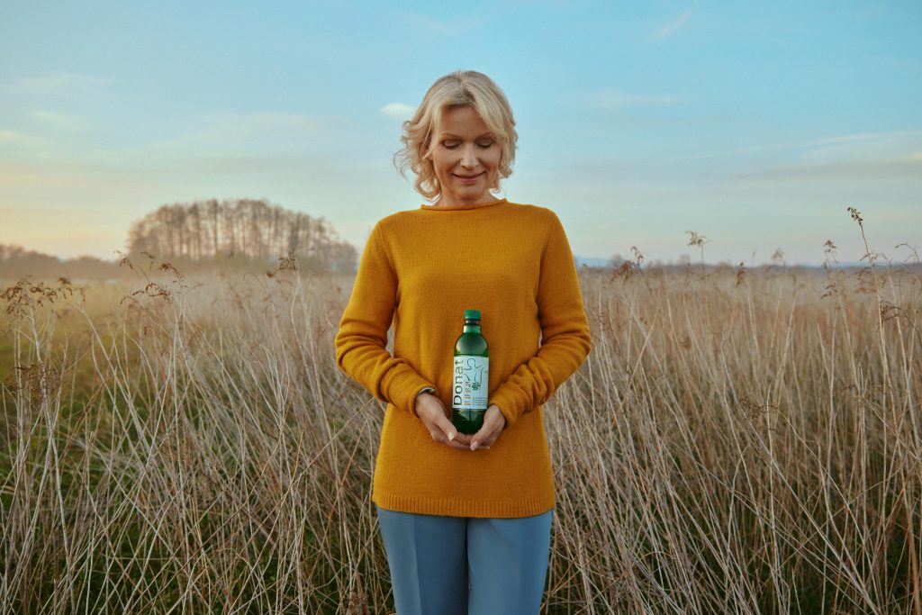 A woman holds a bottle of Donat Mg in her hands.